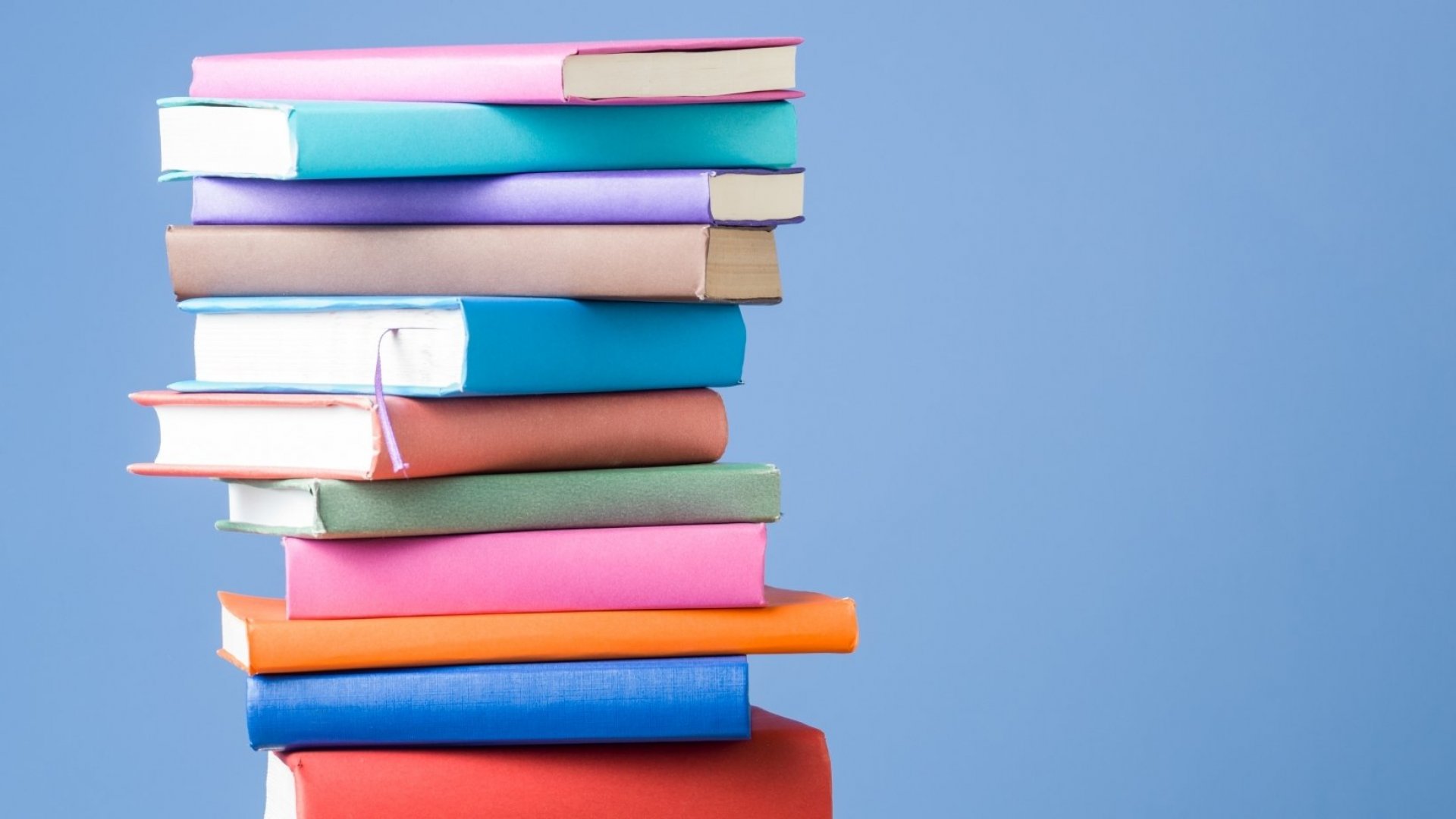 Stack of colorful books with blue background.