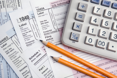 Tax forms, calculator and pencils.