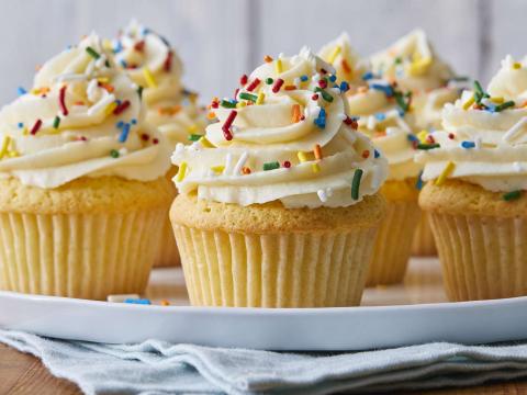 Vanilla cupcakes with swirled vanilla frosting topped with sprinkles