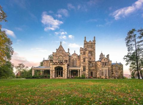 Lyndhurst Castle with a clear blue sky and green lawn in front.