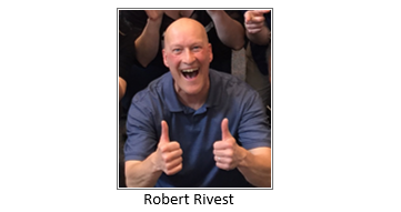 bald man with a big smile and two thumbs up wearing a blue shirt 