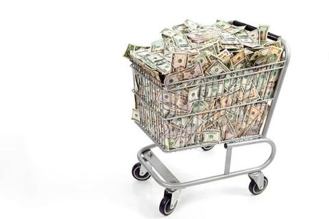 Shopping cart with money in it, white background.