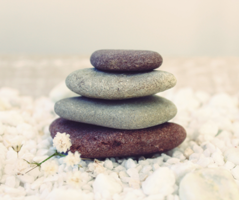 Flat round rocks stacked on top of one another with a white background.