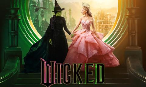 The image is a Wicked movie poster showing two women holding hands.On the left, a green-skinned witch in a black dress and hat stands in green light. On the right, a blonde woman in a pink gown and crown stands in golden light.  They face each other in front of a glowing doorway overlooking the Emerald City. The word “Wicked” appears in bold green and pink letters at the bottom.