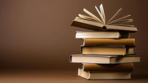 Stack of books with a brown background.