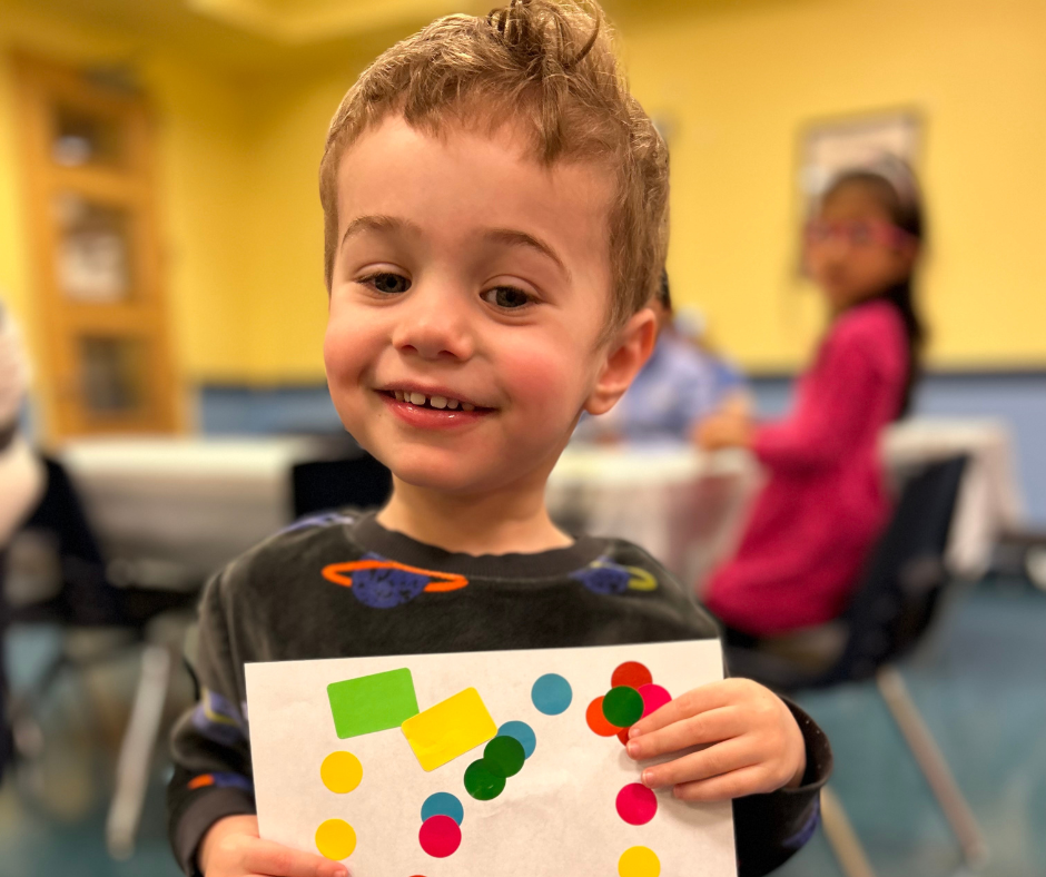 Child holding up a piece of art they created