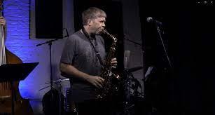 Musician Travis Sullivan performs with a saxophone