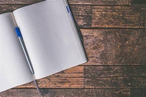 Image of a blank journal open on a wood surface.