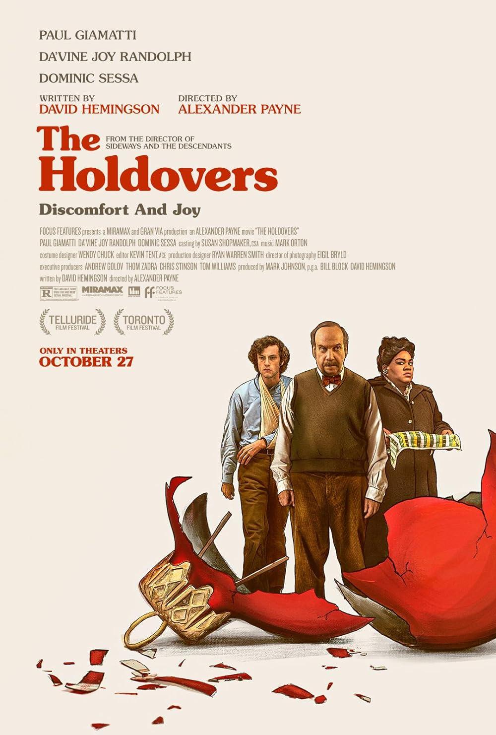 The Holdovers title in red and three people standing there next to a broken red Christmas ornament.