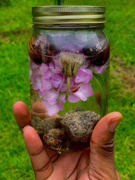 mason jar with pink and purple flowers in water